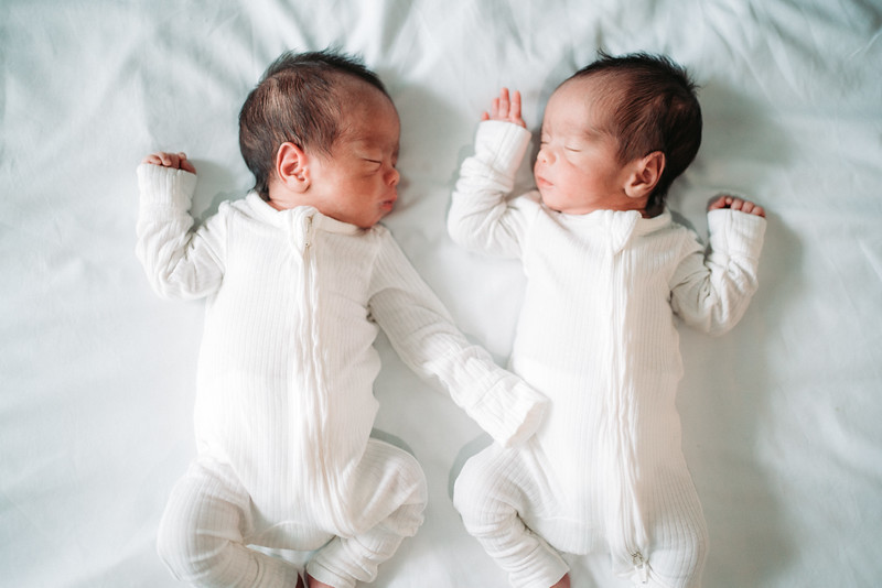 Dos recién nacidos descansando juntos sobre una manta clara