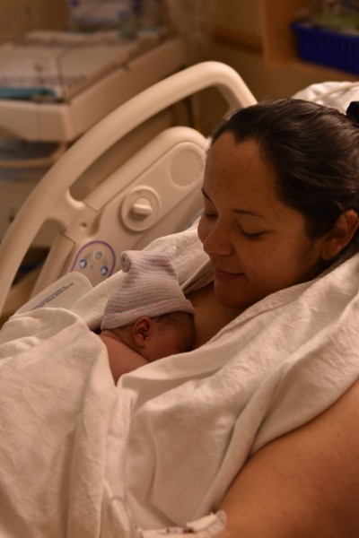 Una madre abrazando a su recién nacido en una cama de hospital